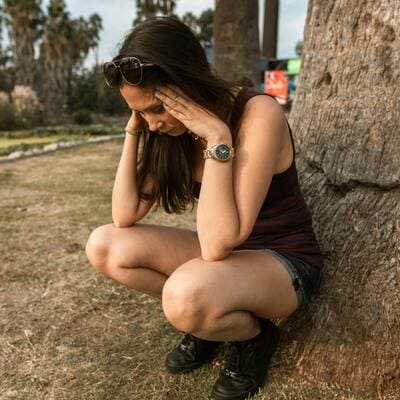Mulher com ansiedade sentada perto de uma janela, simbolizando os desafios emocionais enfrentados na terapia individual.