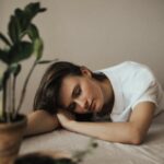 Pessoa exausta e cansada sentada em uma cadeira, simbolizando burnout e a busca por apoio na terapia individual.