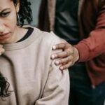 Casal enfrentando sentimentos de ciúmes e insegurança em um ambiente interno, simbolizando os desafios no relacionamento.
